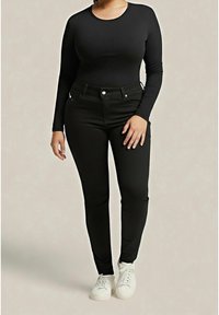 Top negro de manga larga y jeans ajustados negros, ambos hechos de tela elástica. El conjunto se complementa con zapatillas blancas. Diseño limpio sin patrones.