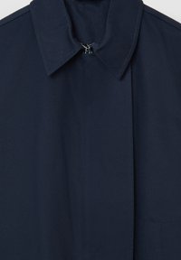 Cappotto blu navy con colletto aperto, chiusura frontale con zip e due tasche laterali. Tessuto liscio con dettagli di cucitura puliti.