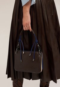 Braune strukturierte Lederhandtasche mit blauen und cremefarbenen Akzenten, ausgestattet mit zwei geknoteten Griffen und silbernem Zubehör. Eignet sich für informelle oder formelle Anlässe.