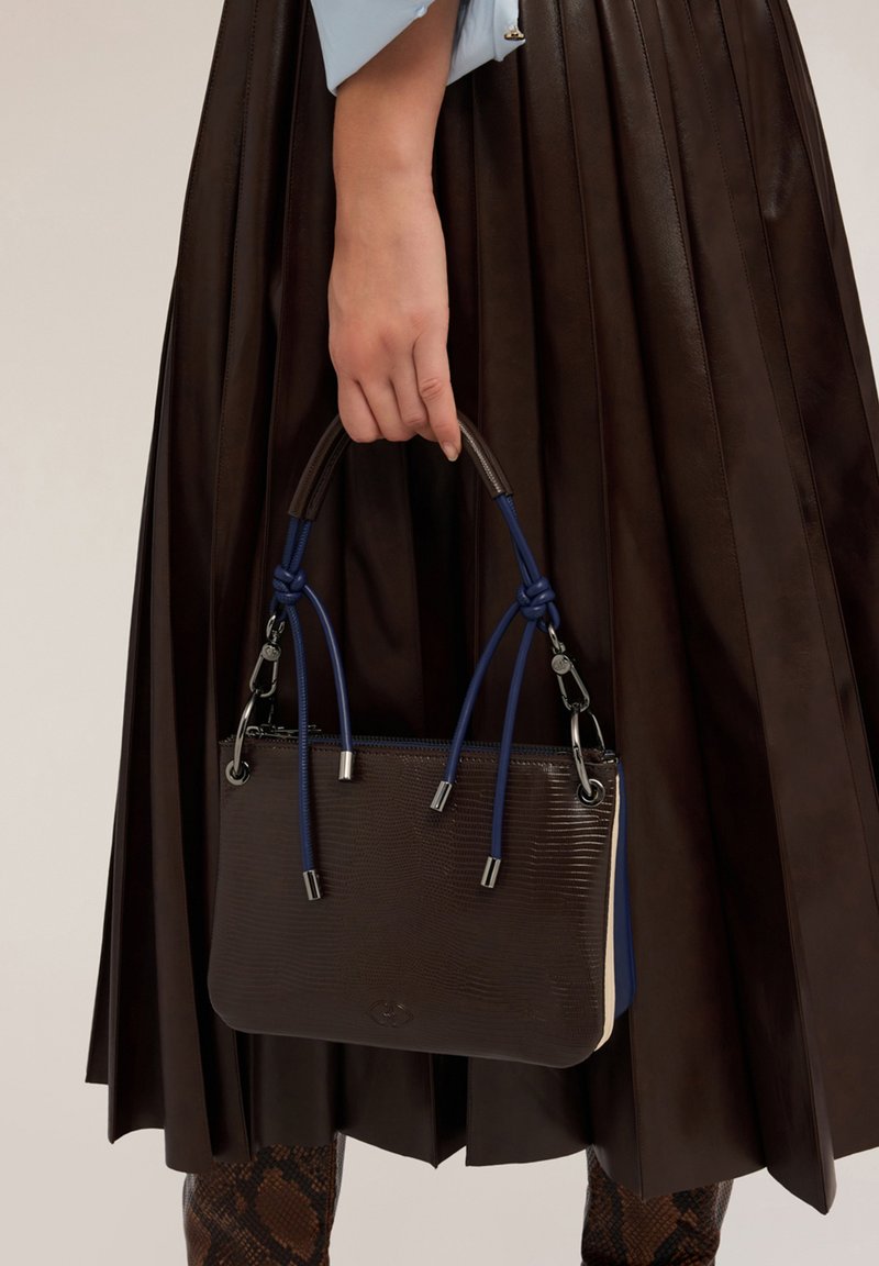 Braune strukturierte Lederhandtasche mit blauen und cremefarbenen Akzenten, ausgestattet mit zwei geknoteten Griffen und silbernem Zubehör. Eignet sich für informelle oder formelle Anlässe.