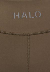 Bruine rekbare stof met een gladde textuur, met een horizontale naad en het woord "HALO" in lichtgrijs aan de bovenkant.