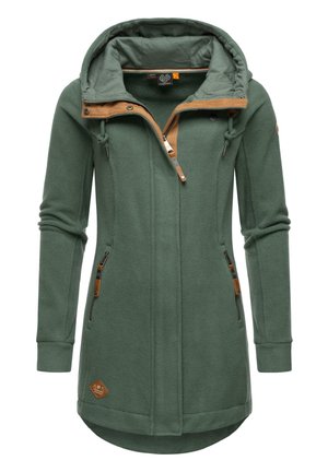 Veste en polaire verte avec un ourlet légèrement incurvé, fermeture éclair à l'avant, deux poches latérales, et un accent beige autour de la capuche et de la zone de la fermeture éclair.