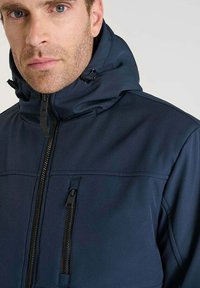 Giacca con cappuccio di colore blu navy realizzata in un tessuto morbido e liscio, dotata di una zip frontale e una tasca sul petto con dettagli di zip nera.