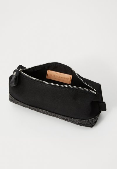 Pochette en tissu noir avec une fermeture éclair argentée. Présente une texture tissée en bas et une étiquette en cuir beige à l'intérieur. Forme rectangulaire.