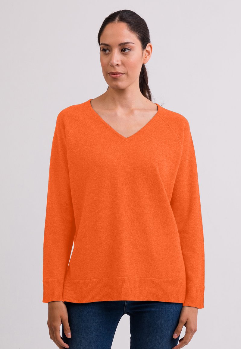 Maglione arancione a maglia con scollatura a V e maniche lunghe raglan. Il tessuto sembra morbido e strutturato, con una vestibilità comoda e polsini a coste.