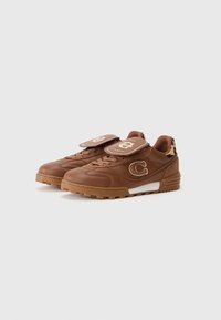 Bruine leren sneakers met gumzolen, omgevouwen tongen met logo's en een leoppardprintdetail op de hiel.