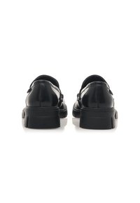 Scarpe in pelle nera con una finitura liscia, retro arrotondato e una spessa suola in gomma nera. Presentano un design semplice senza hardware visibile.