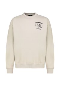 Light beige sweatshirt with a crew neck, ribbed cuffs, and hem. Features a black printed graphic with the text "WORKSHOP" on the chest.
