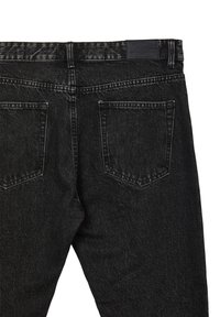 Jeans in denim nero con una trama sbiadita, cinque tasche e un’etichetta in vita. Vestibilità standard con dettagli cuciti sulle cuciture.