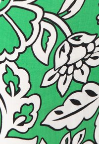 Groene stof met een bloemenpatroon met zwarte omtrekken en witte bladeren. Het ontwerp omvat verschillende vormen en texturen.