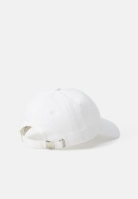 Șapcă de baseball din bumbac alb, cu vizieră curbă, curea ajustabilă în spate și un detaliu cu buton în partea de sus. Textură netedă, design minimalist.