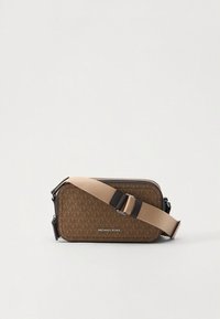 Brun monogram crossbody-taske med lynlåslukning, justerbar beige rem og en glat tekstur, med "MICHAEL KORS" logo foran.