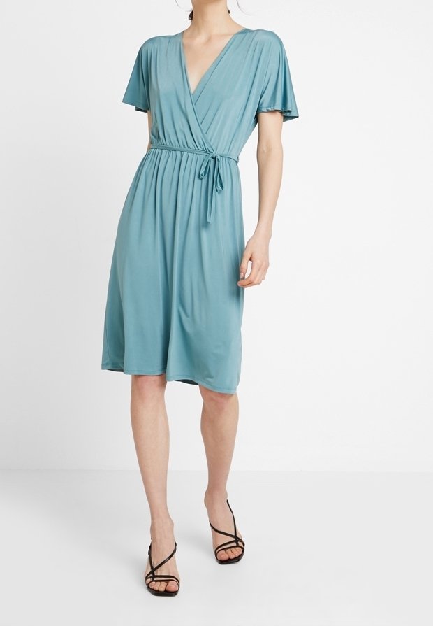Robe portefeuille bleu clair à manches courtes, décolleté en V et taille à nouer. Fabriquée en tissu doux, avec un ourlet au niveau du genou et une texture lisse.