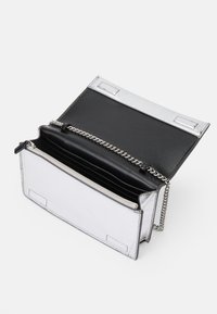 Sudraba un melna maku ar ķēdes siksniņu, ar gludu ārpusi, rāvējslēdzēja kabatu un vairākiem karšu nodalījumiem iekšpusē.