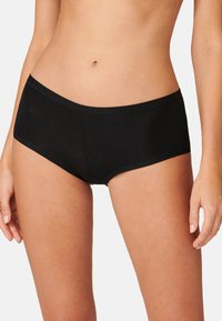 Schwarze Baumwoll-Hipster-Shorts mit einer glatten Textur, elastischem Bund und flachen Nähten, die eine eng anliegende Passform und ein minimales Design bieten.