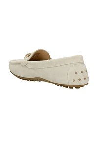 Beige suède instapper met decoratieve hardware, ronde neus en een rubberen zool met textuur. De achterkant heeft stipaccenten voor extra grip en stijl.