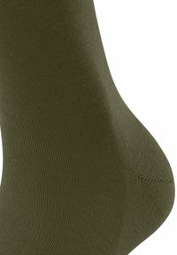 Olijfgroene sok gemaakt van textuurmateriaal, met een naadloze teen en geribbelde ontwerp, wat een soepele en elastische pasvorm benadrukt.