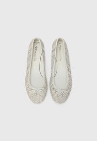 Ljust grå balettklämmor gjorda av perforerat material, med en rosett vid tån och en slät innerfoder. Storlek 37 märkt inuti.