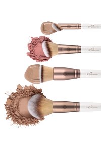 Vier make-upkwasten met witte handvatten en roségouden accenten, met crèmige en poederige texturen in beige, roze en stoffige bruine tinten.