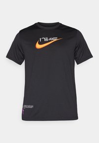 Černé tričko s krátkým rukávem Nike s oranžovým logem swoosh a bílým textem na hrudi, malý bílý a fialový text poblíž spodního lemu.