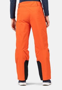 Orange wasserfeste Skihosen mit schwarzen Akzenten, im lässigen Schnitt, verstellbarem Bund und verstärkten Unterschenkeln.