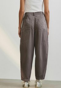 Losse, hoge taille, grijze broek met twee achterzakken, gemaakt van zacht materiaal, met een brede pijpdesign en een elastische tailleband.