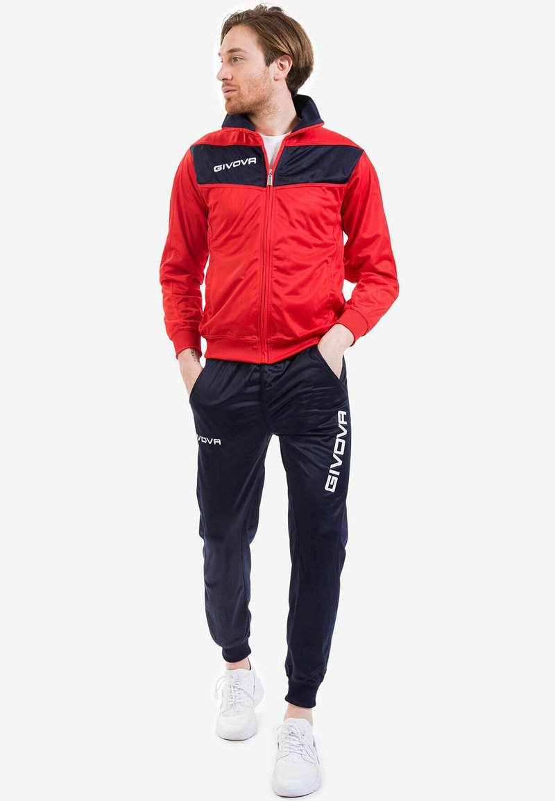 Tuta rossa e blu con giacca con zip e pantaloni a vita elastica, realizzata in materiale morbido con logo "GIVOVA" in bianco.
