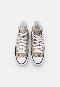 Ein Paar High-Top-Sneaker mit weißen Zehenkappen, weißen Schnürsenkeln und beigen Obermaterialien im Schlangenlederdesign auf einem weißen Hintergrund.