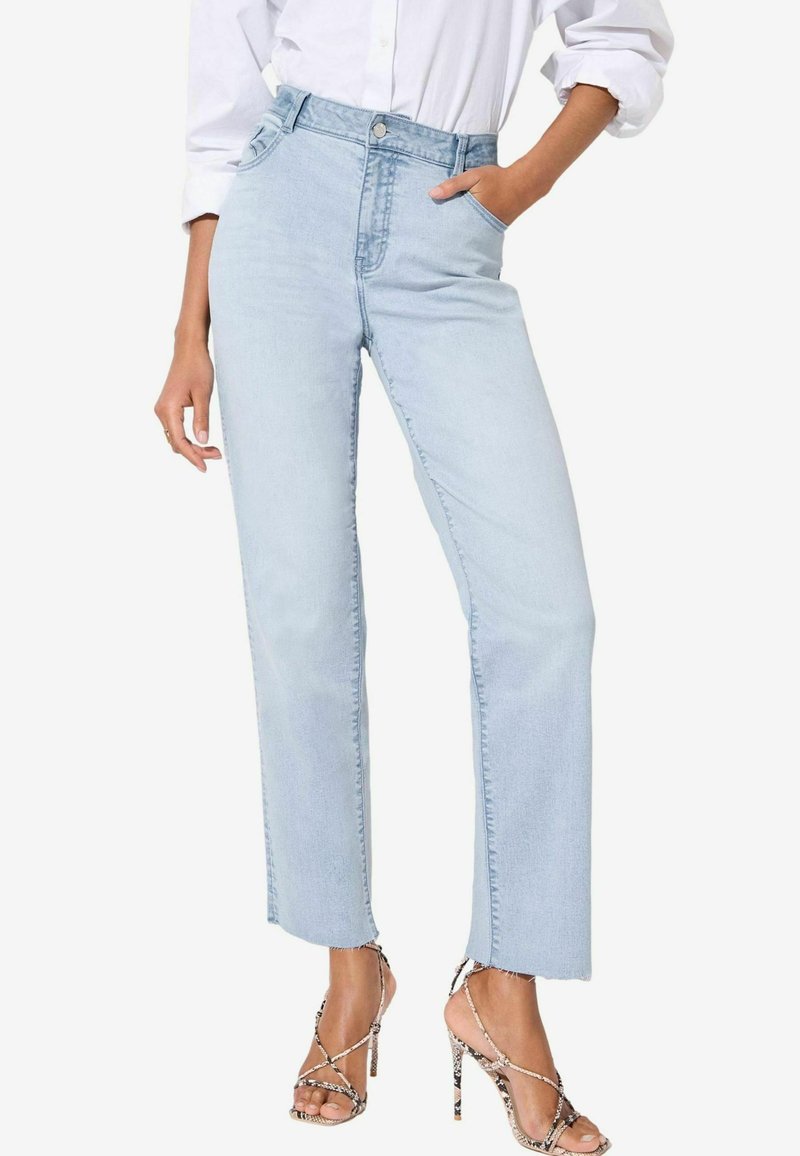 Jeans in denim blu chiaro a vita alta con gamba dritta, tasche frontali e orlo grezzo. Abbinati a sandali con tacco alto e fasce.