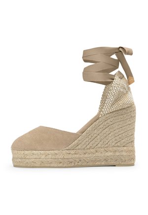 Espadrillas beige in tela con zeppa, suola in corda intrecciata e lacci da annodare alla caviglia, con dettaglio intrecciato sul contrafforte del tallone.