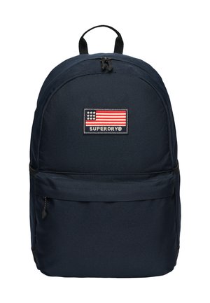 Navyblauer Rucksack mit frontaler Reißverschlusstasche, Tragegriff und Superdry-Logopatch mit stilisierter amerikanischer Flagge.