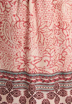 Tessuto di cotone con intricati motivi floreali e geometrici in tonalità di rosso e rosa, con un bordo decorativo in tonalità più scure.