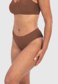 Bruine naadloze bh en bijpassende hoge taille slip, gemaakt van glad, flexibel materiaal. Geribbelde textuur op de tailleband.