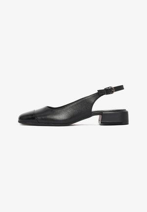 Zwarte leren slingback schoen met lage blokhak, ronde neus en verstelbare gesp aan band, op witte achtergrond.