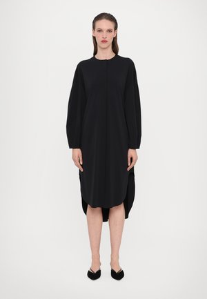 Black long-sleeve dress with a rounded neckline, side slits, and a relaxed fit. Made from smooth fabric with a matte finish.
