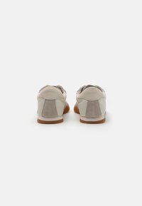 Lette sneakers i lysegrå og beige med semsket skinn-detaljer, som har rund tå, gummisåle og minimal merkevareføring på hælen.