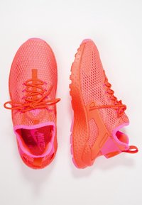 Jasně růžové sportovní boty z síťovaného materiálu s texturovanou podrážkou, kontrastními detaily a kulatým logem na jazyku.