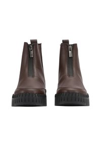 Botines de piel marrón con cremallera frontal, suela de goma y textura estriada. Presentan una textura suave y un diseño minimalista.