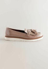 Mocassin en cuir verni beige avec pompons, semelle en caoutchouc blanche, bout arrondi et ornements décoratifs sur la tige.