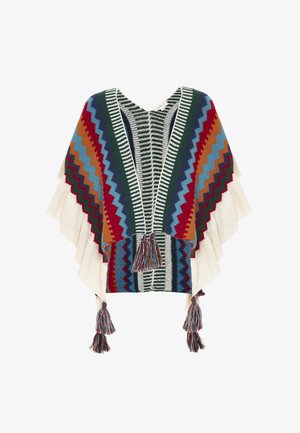 Multikleuren poncho met een zigzagpatroon in rood, blauw en groen. Heeft crème-franje randen en franjes aan de onderkant. Zachte gebreide textuur.