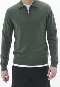 Maglione verde con collo zip, maniche lunghe e orlo a coste. Realizzato in morbido tessuto, presenta un design minimalista.
