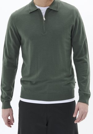 Pull vert avec col zippé, manches longues et ourlet côtelé. Fabriqué en tissu doux, il présente un design minimaliste.