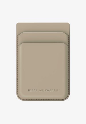 Bežs kredītkaršu turētājs, izgatavots no ādas, ar diviem kredītkaršu slotiem augšpusē un smalku diegu šuvēm. Apakšā ir izspiestā logo.