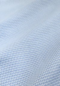 Light blue fabric with a textured, raised woven pattern creating small diamond-shaped indentations.