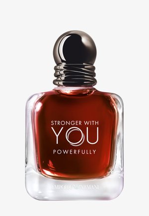 Flacon de parfum en verre contenant un liquide rouge foncé, avec un bouchon rond argenté, étiqueté « Stronger With You Powerfully », marque Emporio Armani à la base.