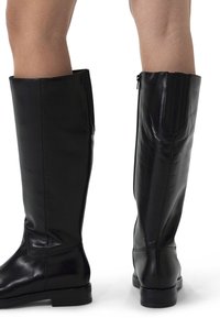 Black leather knee-high boots with a smooth texture, straight design, rounded toe, and side zipper detail. Rubber sole with low heel.