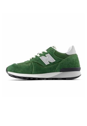 Grüne Wildleder-Laufschuhe mit grauen Akzenten, weißen Schnürsenkeln und einer schwarzen Gummisohle. Verfügt über eine abgerundete Zehenpartie und eine strukturierte Oberfläche für besseren Halt.