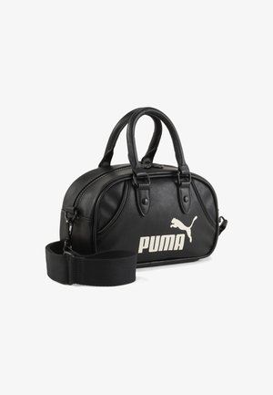 Czarna skórzana torebka na dwa uchwyty, z zamknięciem na zamek i odpinanym paskiem. Posiada białe logo "PUMA" oraz wzór skaczącego pumy.