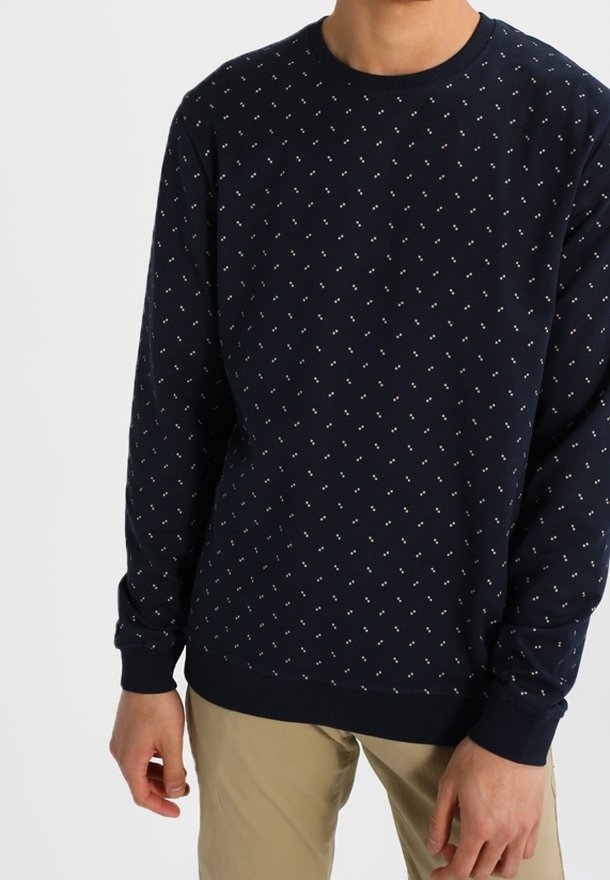 Felpa a manica lunga di colore navy, realizzata in un tessuto morbido, con piccoli motivi decorativi bianchi e azzurri. Collo rotondo e polsini a costine.
