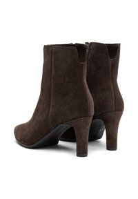 Rjavi nubuk škornji do gležnjev z gladko teksturo, koničastimi petami in stranskimi zadrgami. Oblikovanje vključuje eleganten silhuet in minimalne detajle.